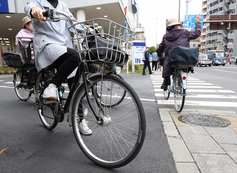 信号の前で一時停止する自転車の利用者（手前）＝東京都墨田区で2026年3月27日午前10時11分、後藤由耶撮影