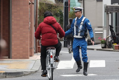 一時停止を守らずに道路を横断した自転車の利用者を取り締まりのために停車させる警察官＝東京都墨田区で2026年3月27日午前10時14分、後藤由耶撮影