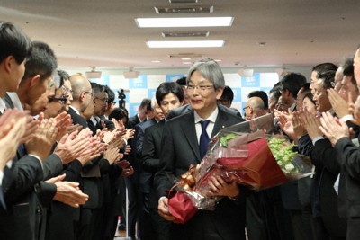 贈られた花束を手に、職員らに拍手で見送られる服部洋平副知事（中央）＝県庁で2026年3月31日午後4時21分、稲生陽撮影