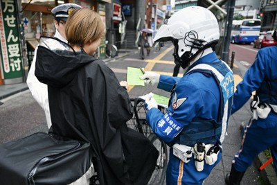 一時停止の標識に従わなかったため、警察官から警告を受ける自転車の利用者＝東京都北区で2026年4月1日午前9時17分、藤井達也撮影