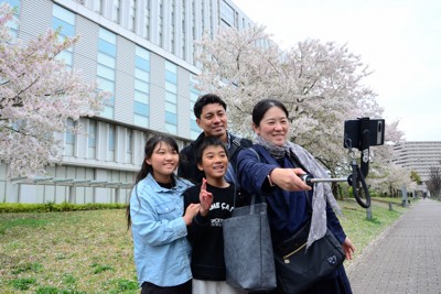 事実婚の古賀礼子さん（右端）、稲坂将成さん（奥）の家族は1日、単独親権から共同親権に変更する調停を東京家裁立川支部に申し立て、家裁前で記念撮影した＝東京都立川市で2026年4月1日午前10時22分、巽賢司撮影