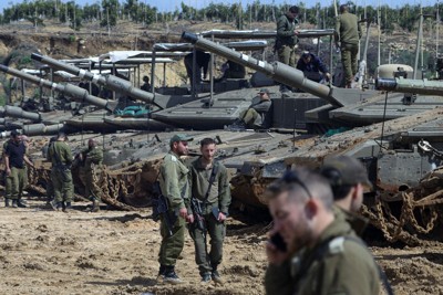 戦車の近くに立つイスラエル軍の兵士＝イスラエル北部のレバノンとの国境付近で2026年3月26日、ロイター