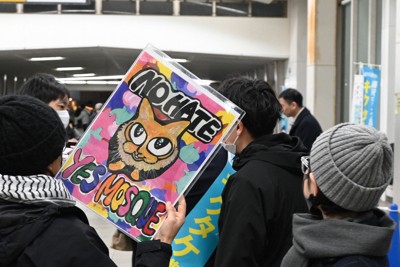 ユーチューバーが選挙演説する前で、「NO　HATE　YES　MOSQUE」（ノーヘイト　イエスモスク）と書かれたプラカードを掲げる市民＝神奈川県藤沢市のJR辻堂駅で2026年2月6日午後6時30分、矢野大輝撮影