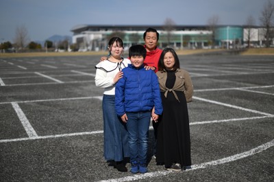 車中泊を続けた駐車場で写真に納まる（右から）大山るみさん、祐介さん、裕己さん、愛歩さん＝熊本県益城町で2026年3月22日、久保玲撮影