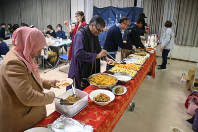 交流会で、ラマダン（イスラム教の断食月）の日没後の食事「イフタール」を楽しむ人たち。日本人も参加した＝神奈川県綾瀬市で2026年3月8日午後6時10分、矢野大輝撮影