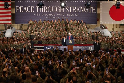 「力による平和」の横断幕がある米空母で演説するトランプ米大統領（中央右）と高市早苗首相（米海軍横須賀基地で昨年10月28日）
