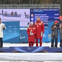 ノルディックスキー距離女子10キロクラシカル視覚障害の表彰式で、優勝したロシア選手（中央左）から距離を置いて記念撮影する2位のチェコ選手（左端）。中央に集まる様子は見られなかった＝テーゼロ距離競技場で2026年3月11日、渡部直樹撮影