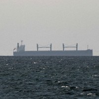 ホルムズ海峡付近を航行する貨物船＝アラブ首長国連邦とオマーンの国境付近で2026年3月11日、ロイター
