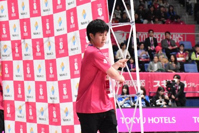 試合直後、ヒーローインタビューに使うバックボードをコート内に運ぶ山上優太さん＝東京・有明コロシアムで2026年2月28日、小林悠太撮影