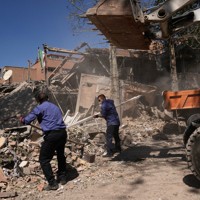 空爆を受けたとされる大学の建物のがれきを取り除く人々＝テヘランで2026年4月6日、AP