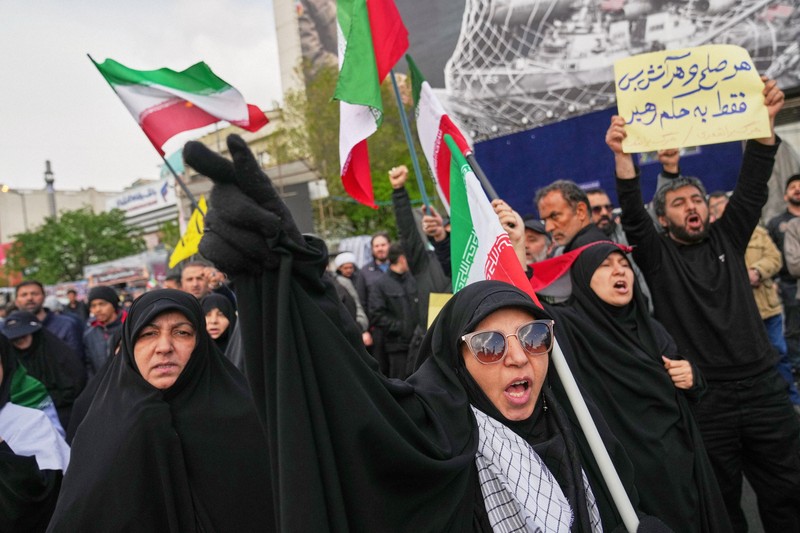 米国やイスラエルとの停戦発表を受け、街中で体制のスローガンを唱える支持者＝イランの首都テヘランで2026年4月8日、AP