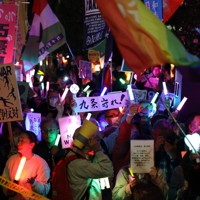 改憲への動きや戦争に反対の声を上げるデモの参加者たち＝国会前で2026年4月8日午後7時半、後藤由耶撮影