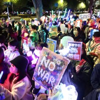改憲への動きや戦争に反対の声を上げるデモの参加者たち＝国会前で2026年4月8日午後8時15分、後藤由耶撮影