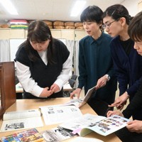 ろうあ被爆者の体験が掲載された雑誌などを眺める全通研長崎支部のメンバー＝長崎市橋口町で2026年3月29日午前11時24分、尾形有菜撮影