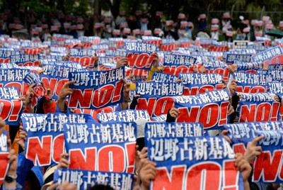 「辺野古新基地NO！」と書かれたメッセージを掲げる「沖縄県民大会」の参加者たち＝那覇市の奥武山陸上競技場で2018年8月11日、望月亮一撮影