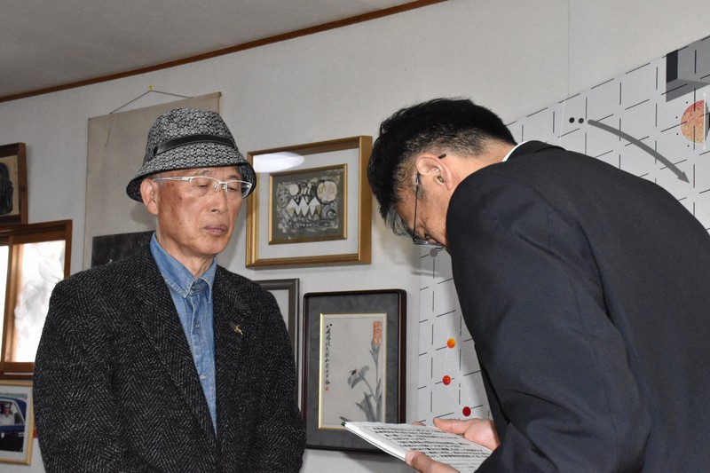 池上治男さん（左）に謝罪する道警保安課の徳田一志課長＝北海道砂川市で2026年4月9日、小林大輝撮影