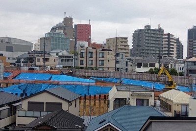 マンション建設現場の遠景。重機が置かれ、地面にブルーシートがかけられたままになっている＝東京都渋谷区で2026年4月4日午前11時12分、寺田剛撮影