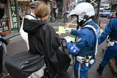 一時停止の標識に従わなかったため、警察官から警告を受ける自転車の運転手＝東京都北区で2026年4月1日午前9時17分、藤井達也撮影