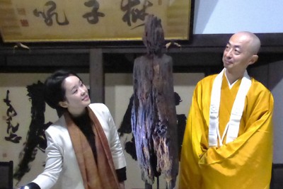 焼損菩薩立像の修復をライトを当てて説明する宮木菜月さん（左）と松村実昭貫主＝葛城市の当麻寺中之坊で2026年4月10日午前11時13分、皆木成実撮影