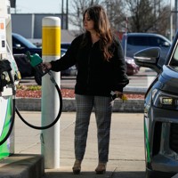 給油前にガソリン価格を確認する女性＝米中西部イリノイ州のガソリンスタンドで2026年4月7日、AP