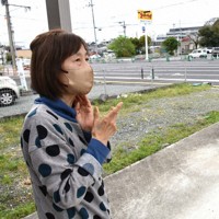 4車線化された県道熊本高森線（奥）を見つめながら、自宅の建て直しなどについて不安を口にする小嶺ひろ子さん＝熊本県益城町で6日、日向米華撮影