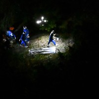 子どもとみられる遺体が見つかった現場付近を調べる捜査員ら＝京都府南丹市で2026年4月13日午後7時38分、本社ヘリから大西岳彦撮影