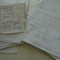 詐欺拠点で見つかった、架電状況などを記した日本語のメモ。警察官役の役名も書かれている＝タイ東北部スリン県近郊のカンボジアとの国境地帯で2026年4月7日、国本愛撮影