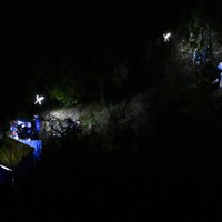 子どもとみられる遺体が見つかった現場付近を調べる捜査員ら＝京都府南丹市で2026年4月13日午後7時38分、本社ヘリから大西岳彦撮影