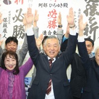 当選を決め支持者とバンザイする阿部裕行氏（中央）＝東京都多摩市で2026年4月12日午後9時40分、矢野純一撮影
