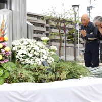 震災記念公園で献花し、手を合わせる人たち＝熊本県益城町で2026年4月14日午前8時59分、金澤稔撮影