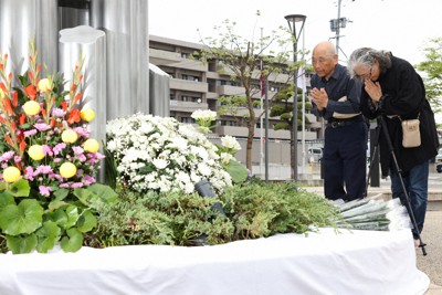 震災記念公園で献花し、手を合わせる人たち＝熊本県益城町で2026年4月14日午前8時59分、金澤稔撮影