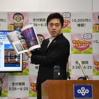 みんなでつくった万博写真集を紹介する吉村洋文・大阪府知事＝大阪市で2026年4月8日午後2時3分、面川美栄撮影