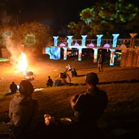 「同窓会」で壁などに映し出されたプロジェクションマッピングの映像＝熊本県西原村の風の里キャンプ場で2026年4月11日午後7時39分、矢頭智剛撮影