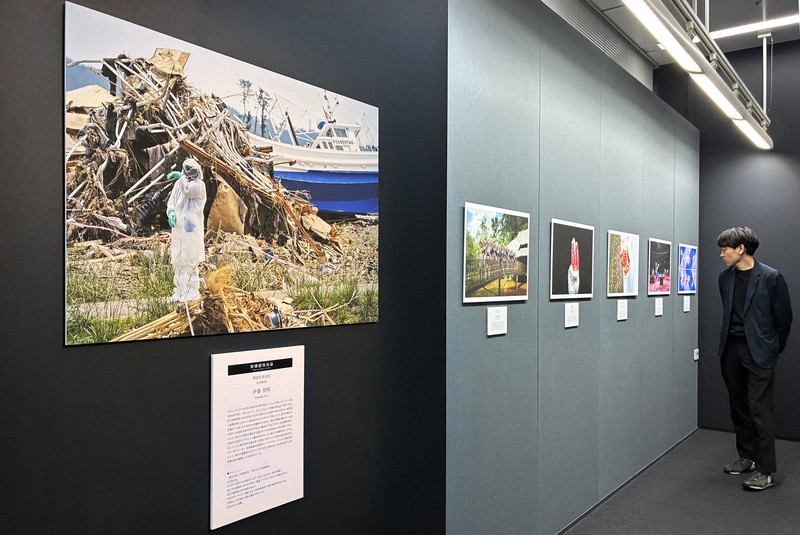報道写真記者と広告写真家の作品が交互に並ぶ会場＝港区で2026年4月13日、小出洋平撮影