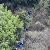 子どもとみられる遺体が見つかった現場周辺を調べる捜査員ら＝京都府南丹市で2026年4月14日午前10時3分、本社ヘリから大西岳彦撮影