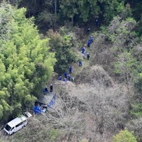 子どもとみられる遺体が見つかった現場周辺を調べる捜査員ら＝京都府南丹市で2026年4月14日午前10時3分、本社ヘリから大西岳彦撮影