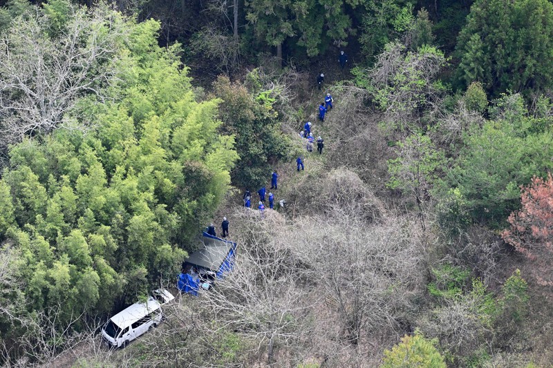 子どもとみられる遺体が見つかった現場周辺を調べる捜査員ら＝京都府南丹市で2026年4月14日午前10時3分、本社ヘリから大西岳彦撮影