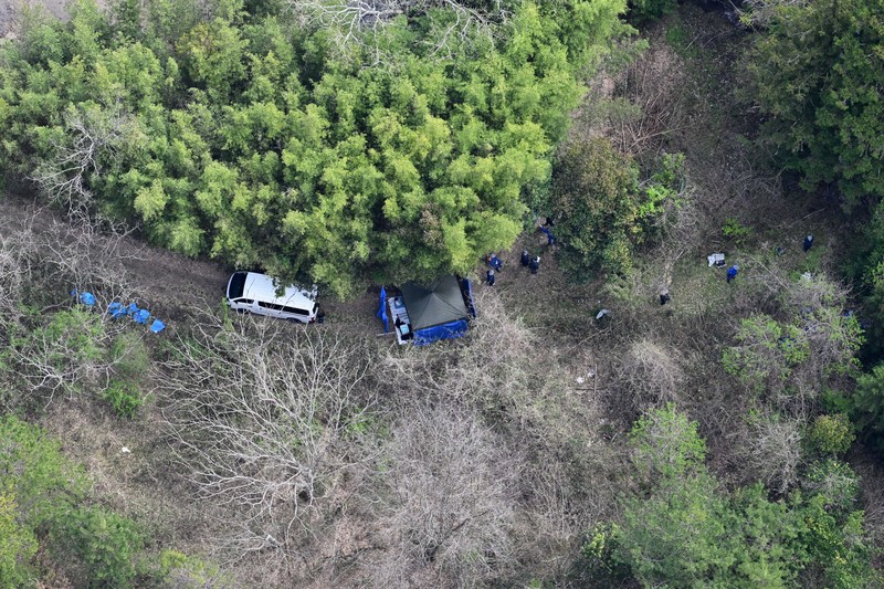 子どもとみられる遺体が見つかった現場周辺を調べる捜査員ら＝京都府南丹市で2026年4月14日午前9時53分、本社ヘリから大西岳彦撮影