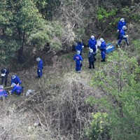 子どもとみられる遺体が見つかった現場周辺を調べる捜査員ら＝京都府南丹市で2026年4月14日午前10時2分、本社ヘリから大西岳彦撮影