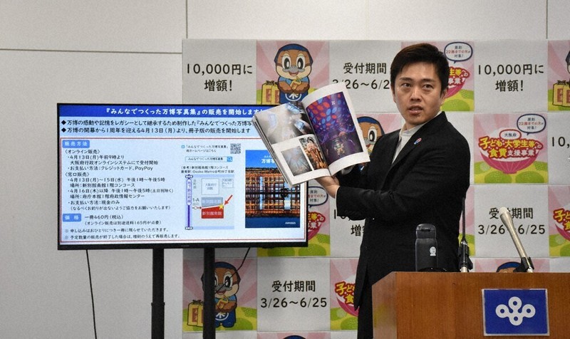 「みんなでつくった万博写真集」を紹介する吉村洋文知事＝面川美栄撮影