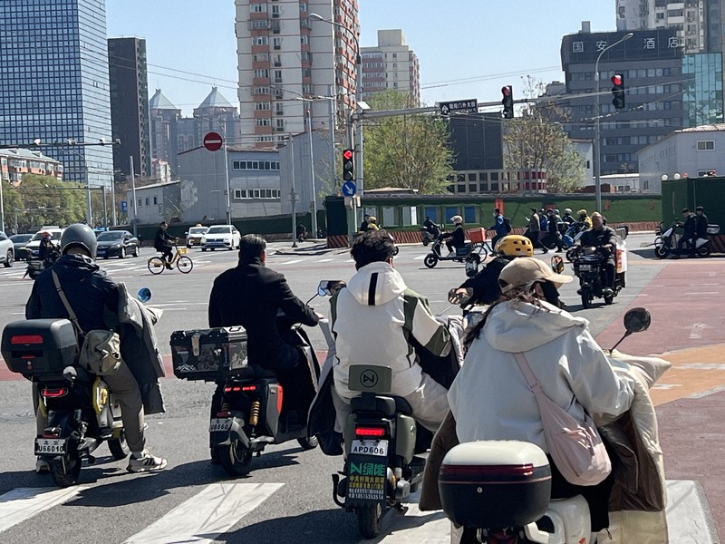 中国の路上では電動バイクが所狭しと走っている＝北京市で2026年4月11日、松倉佑輔撮影