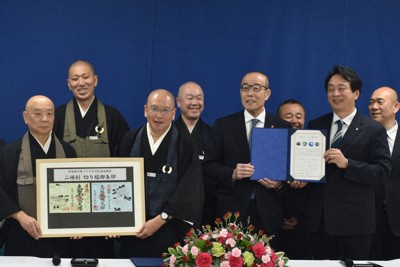 オリジナルの「切り絵御朱印」と協定合意書を手にする（前列左から）総持寺祖院の勝田浩之監院、永平寺の小林昌道監院、石川県輪島市の坂口茂市長、福井県永平寺町の河合永充町長ら＝石川県輪島市門前町で、中尾卓英撮影