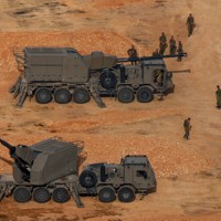 軍用車両の隣を歩くイスラエル軍の兵士＝イスラエル北部のレバノンとの国境近くで2026年4月15日、ロイター