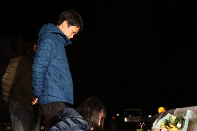 大和晃さんを追悼し、旧阿蘇大橋の近くでろうそくに火をつける母の忍さん（手前）と兄の翔吾さん＝熊本県南阿蘇村で2026年4月16日午前1時25分、金澤稔撮影