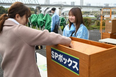 自分で決めた入場料を現金で支払うSPシートの来場者（左）＝東京都江東区の夢の島競技場で2026年4月4日午後4時37分、川村咲平撮影
