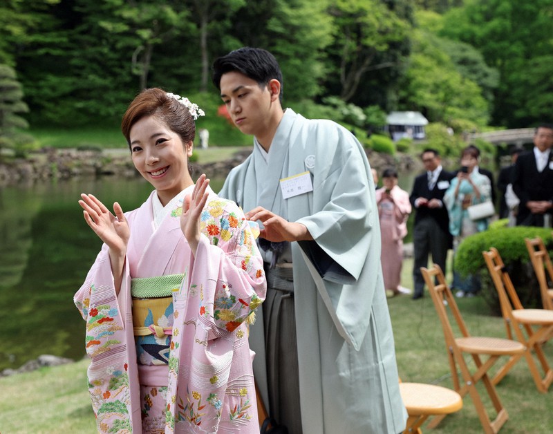 春の園遊会会場で三浦璃来さん（左）の帯を直す木原龍一さん＝東京・元赤坂の赤坂御苑で2026年4月17日午後1時12分、幾島健太郎撮影