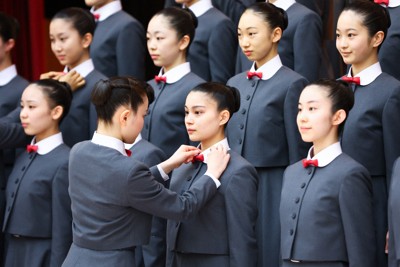 宝塚音楽学校の入学式前の記念撮影で、本科生に制服を整えてもらう新入生＝兵庫県宝塚市で2026年4月18日午前9時11分、前田梨里子撮影