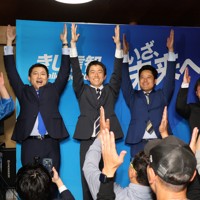 初当選を決め、支持者と万歳をする貴志信智氏（中央）＝久喜市で、2026年4月20日午前0時2分、鷲頭彰子撮影