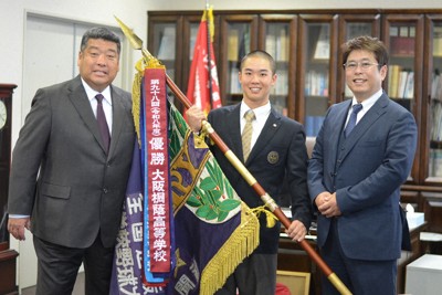ペナントを取り付けたセンバツ優勝旗を囲む大阪桐蔭の平井了校長（右）と黒川虎雅主将（中央）、西谷浩一監督＝大東市の同校で2026年4月20日午前10時9分、藤河匠撮影