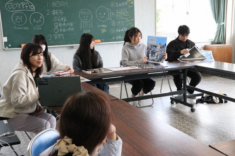自ら撮影した写真を手に韓国での活動を報告する中高生ら＝山口県宇部市床波の西岐波ふれあいセンターで2026年4月19日午前10時32分、綿貫洋撮影